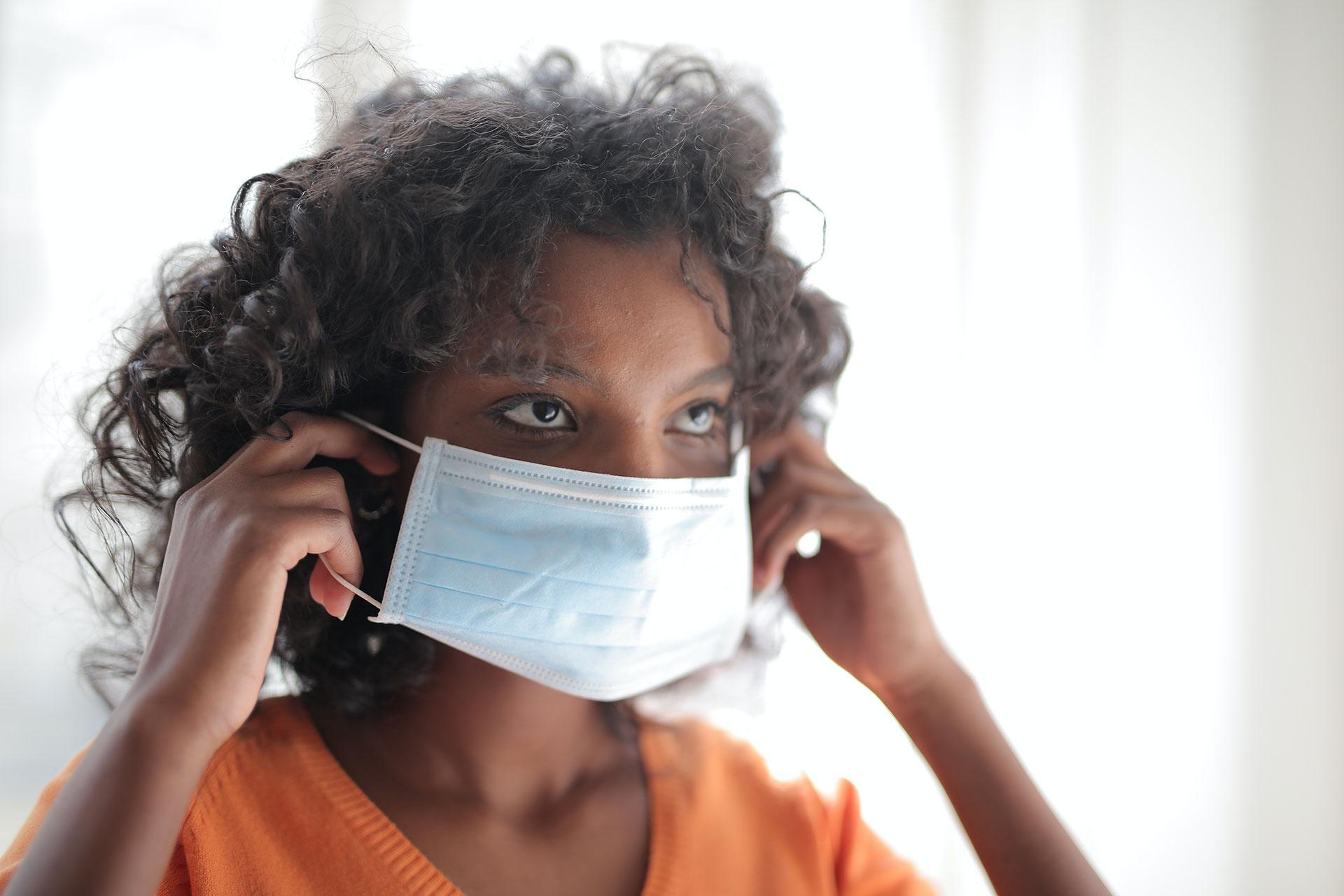 Black woman wearing a mask. 